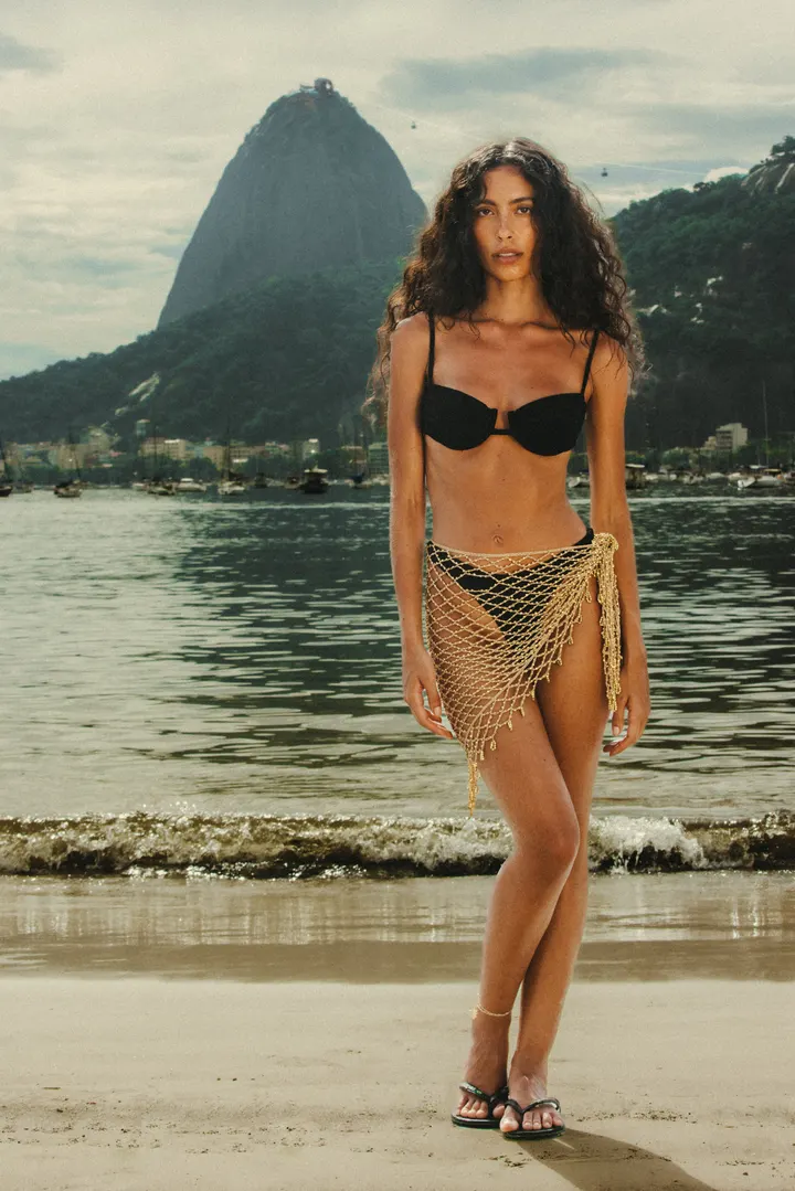 Model in a black bikini on a beach below Sugarloaf Mountain